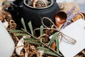 A tea pot and some herbs on the table