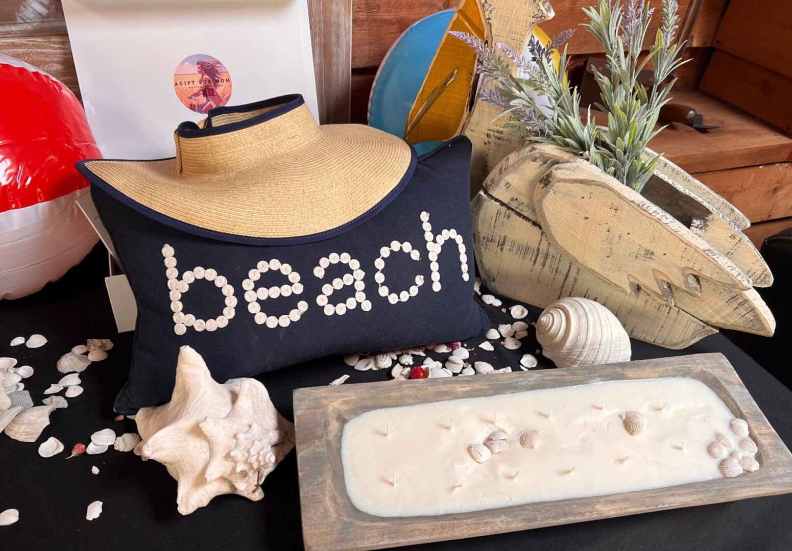 12 wick dough bowl candle with seashells in it, a fun pack and go hat, and medium neck pillow